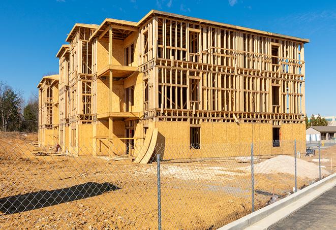 a close-up of temporary chain link fences enclosing a construction site, signaling progress in the project's development in Nuevo CA